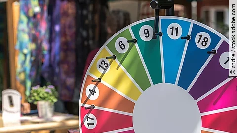Ein Glücksrad in den Farben Rot, Grün, Gelb, Blau und Magenta und verschiedenen Zahlen
