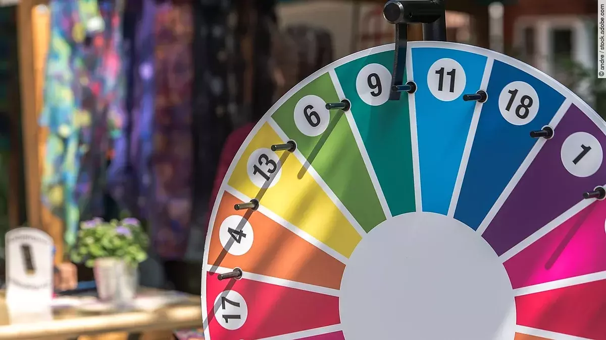 Ein Glücksrad in den Farben Rot, Grün, Gelb, Blau und Magenta und verschiedenen Zahlen